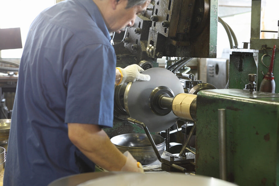 A River Light craftsman shaping an iron pan in the workshop in Japan