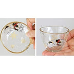 Clear glass sake cup and plate showing calico cat print detail