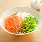 Sliced carrots onions and peppers prepared with BENRINER mandoline slicer on soba noodles