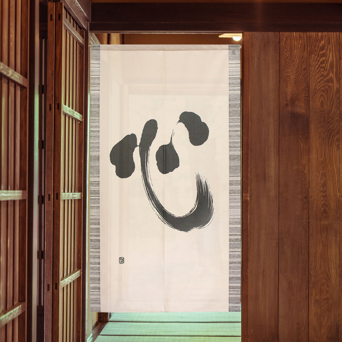 Cosmos Noren with kokoro kanji in cream and black hanging in doorway