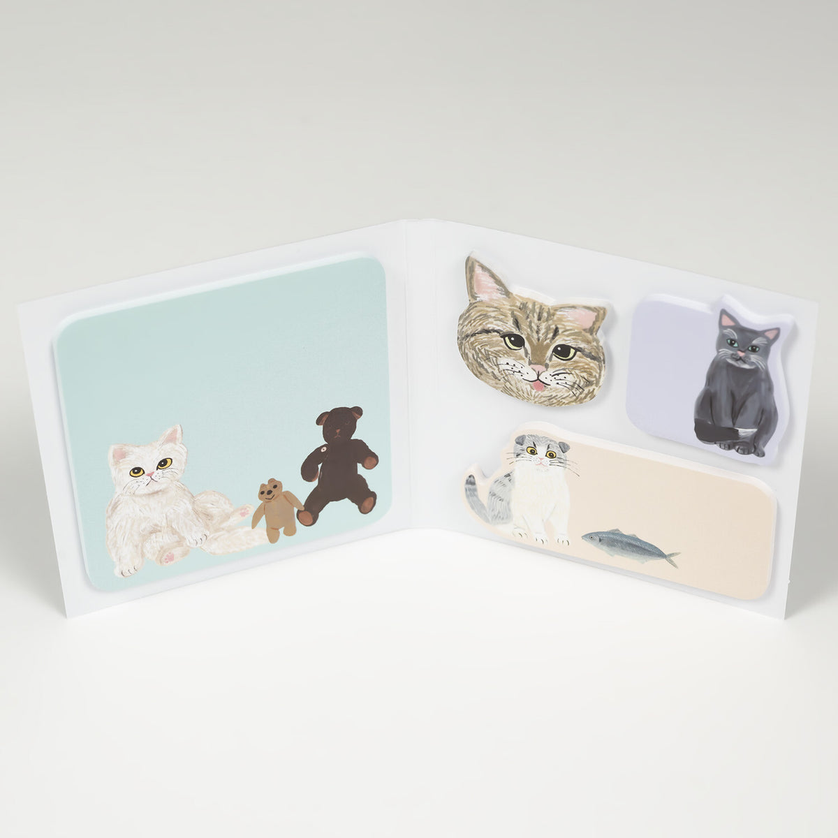 Open folding book sticky notes showing mint square and three shaped cat notes