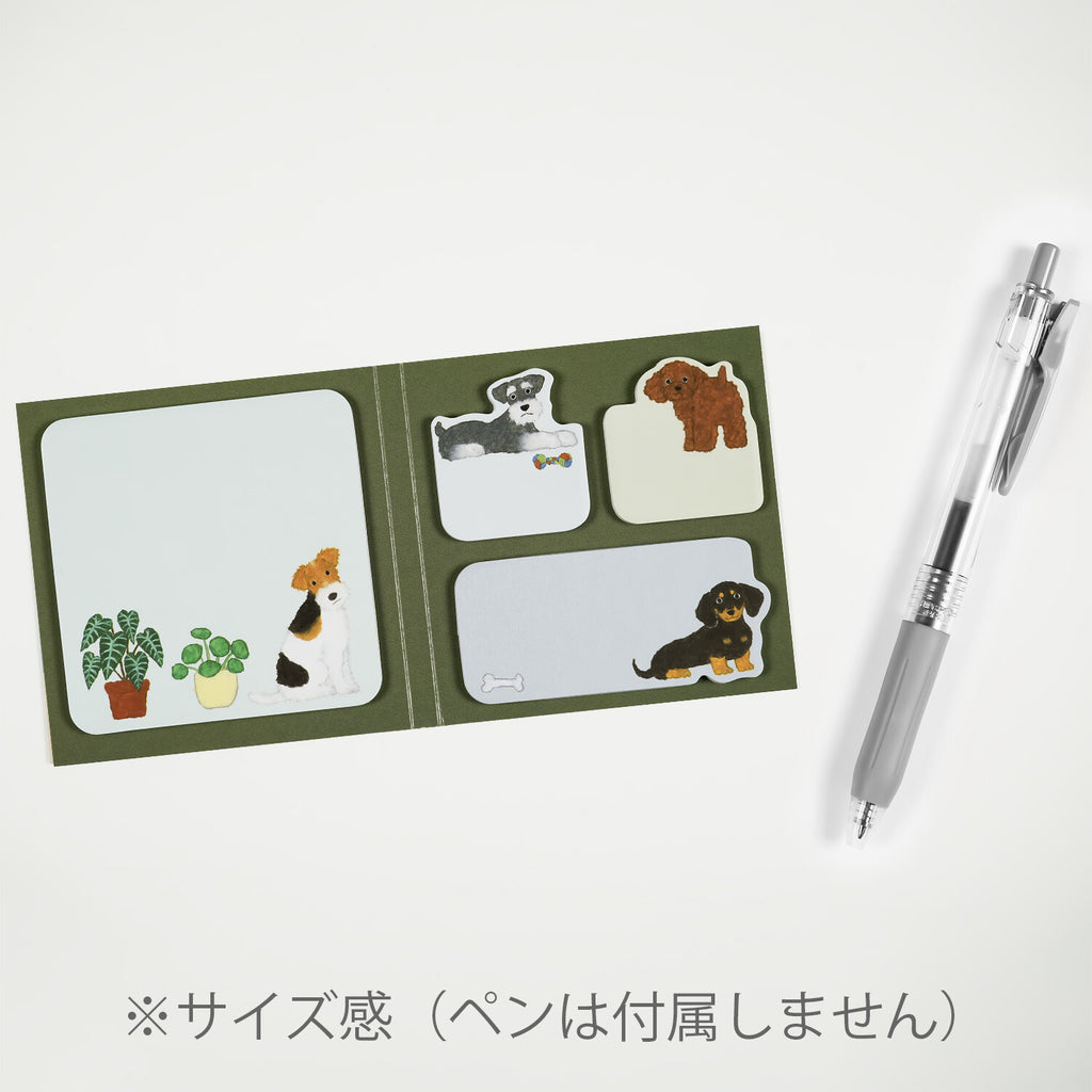 Dog-themed sticky note set open flat with mechanical pen for scale showing Japanese text