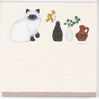 Lined note page illustration of white cat with floral vases and purple patterned strip