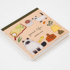 Thick square memo pad showing stacked paper layers and illustrated cat cover art