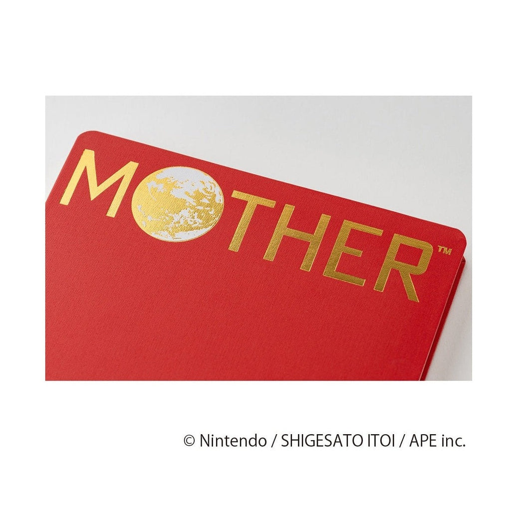Close-up of red woven fabric cover with bold gold MOTHER lettering and globe graphic