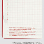 Open planner page showing red grid pattern alongside Japanese text columns