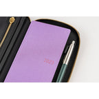 Hobonichi Techo Weeks Notte cover holding purple 2023 notebook and pen