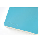 Close-up of aqua blue Hobonichi Techo 2024 cover with embossed logo and cream pages
