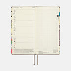 February 2024 open weekly planner spread with illustrated comic-style spine
