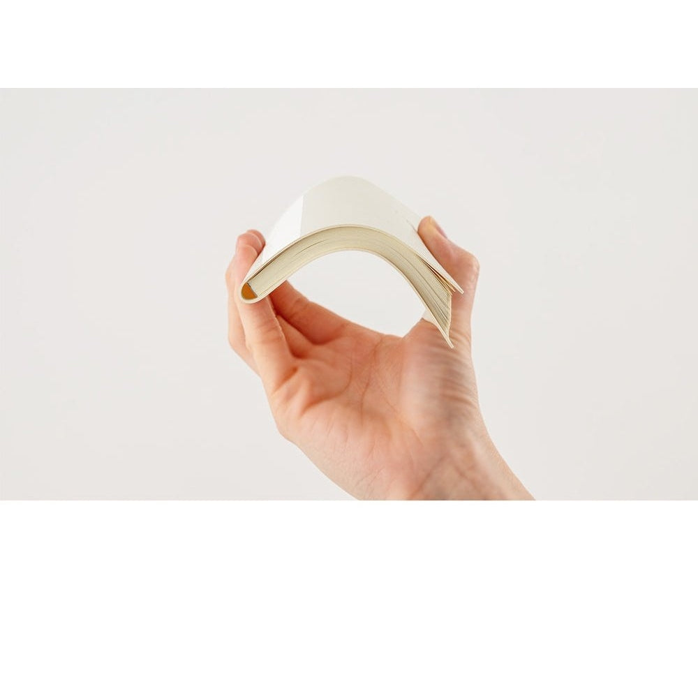 Flexible cream Hobonichi Techo 2024 softcover held curved to show bendable spine design