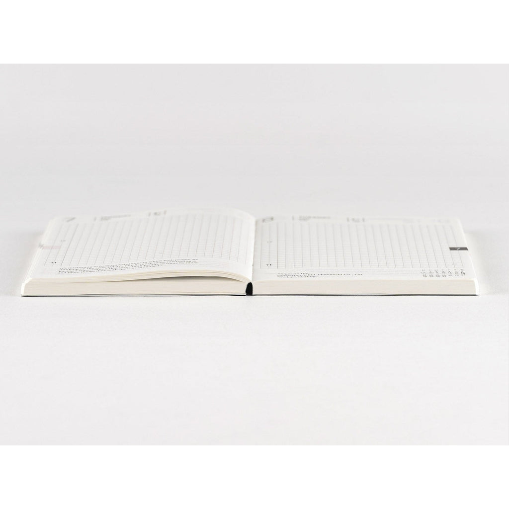 Top-down view of Hobonichi Techo 2025 open planner with subtle dot grid and bookmark tab