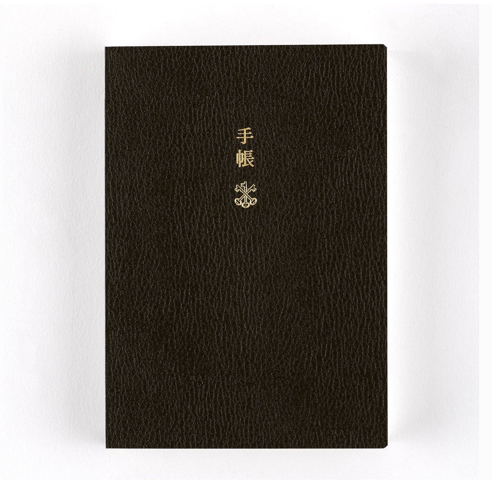 Upright black Hobonichi Techo 2025 planner with pebbled texture and gold foil title text
