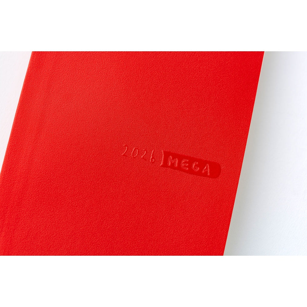 Close-up of raised 2026 MEGA logo on textured tomato red Hobonichi diary cover