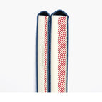 Spines of two Hobonichi planners showing blue fabric edges and red striped page markers