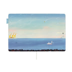 Hobonichi Techo A5 cover art depicting yellow cranes, lighthouse beam, and city skyline at dawn