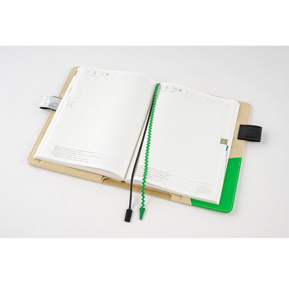 Flat lay of open Hobonichi Techo A5 cover displaying date headers and wavy bookmark