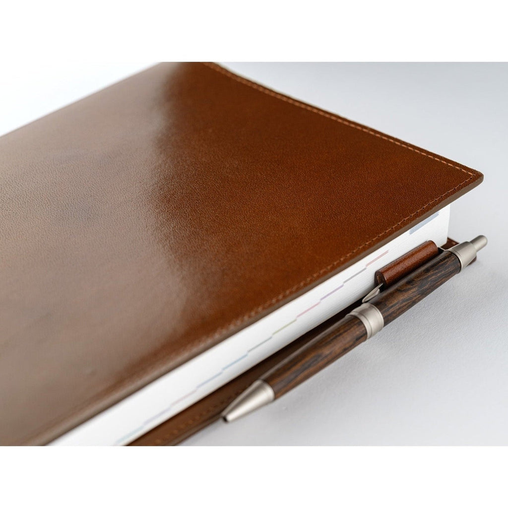 Side detail of brown leather Hobonichi cover with pen in loop