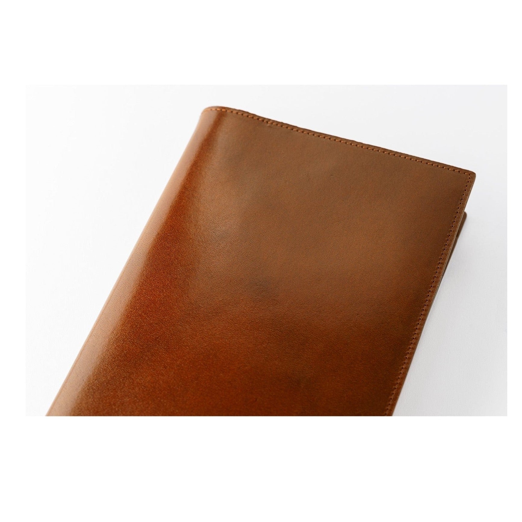 Close-up corner showing fine grain and stitching on brown leather cover