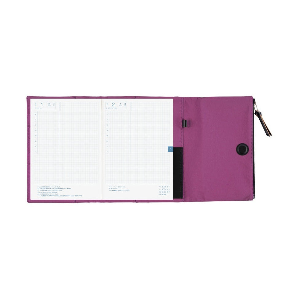 Open Hobonichi Techo A5 purple planner cover displaying grid pages and interior pockets