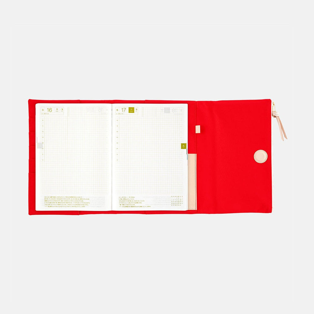 Red Hobonichi Techo A5 Tragen cover holding grid planner with date headers visible