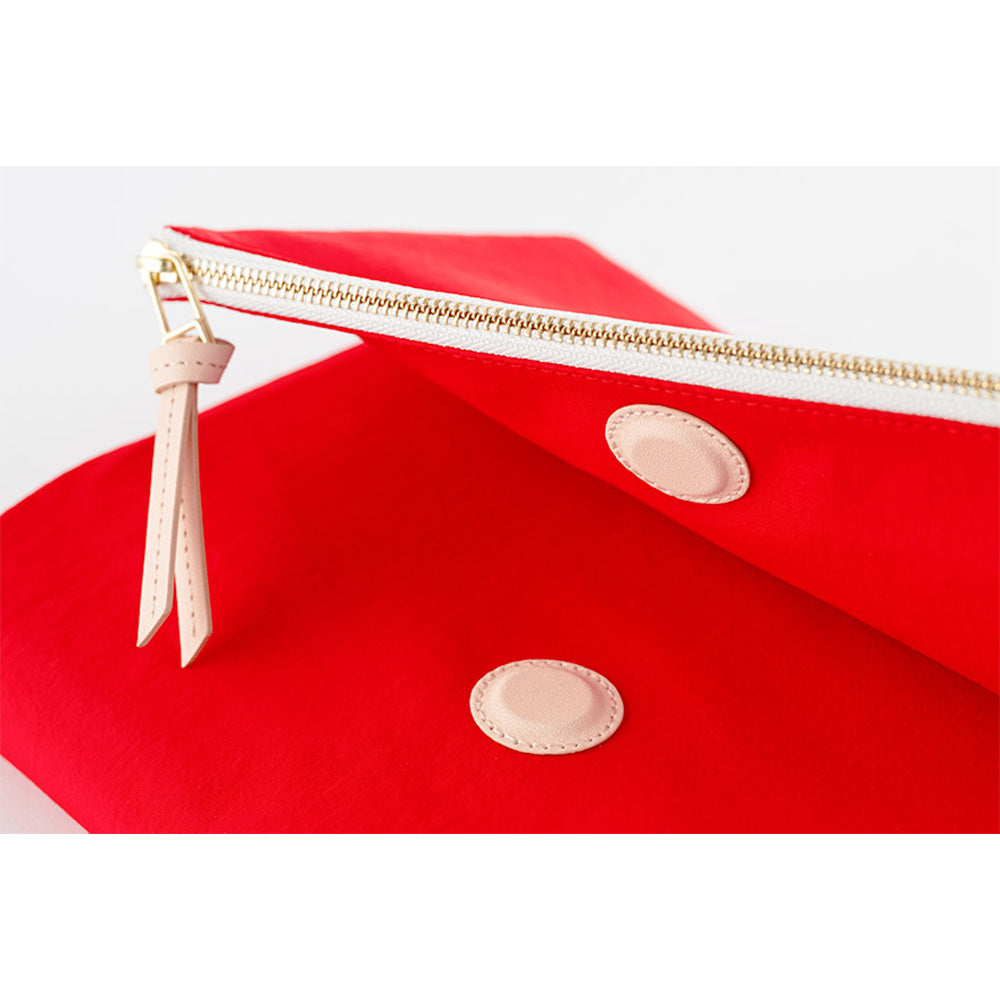 Angled close-up of red Hobonichi Techo A5 cover showing gusseted profile and leather patches