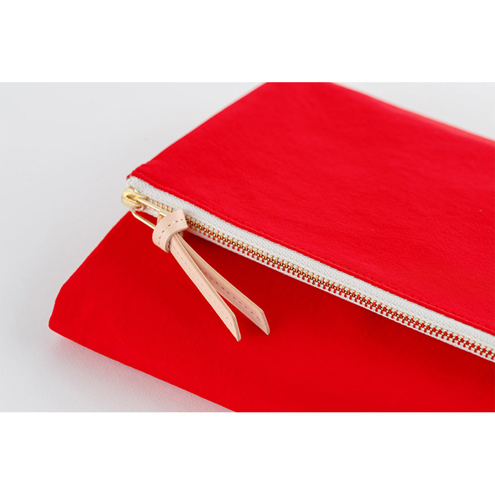 Detail shot of red nylon Hobonichi Techo A5 cover zipper with beige leather pull tab
