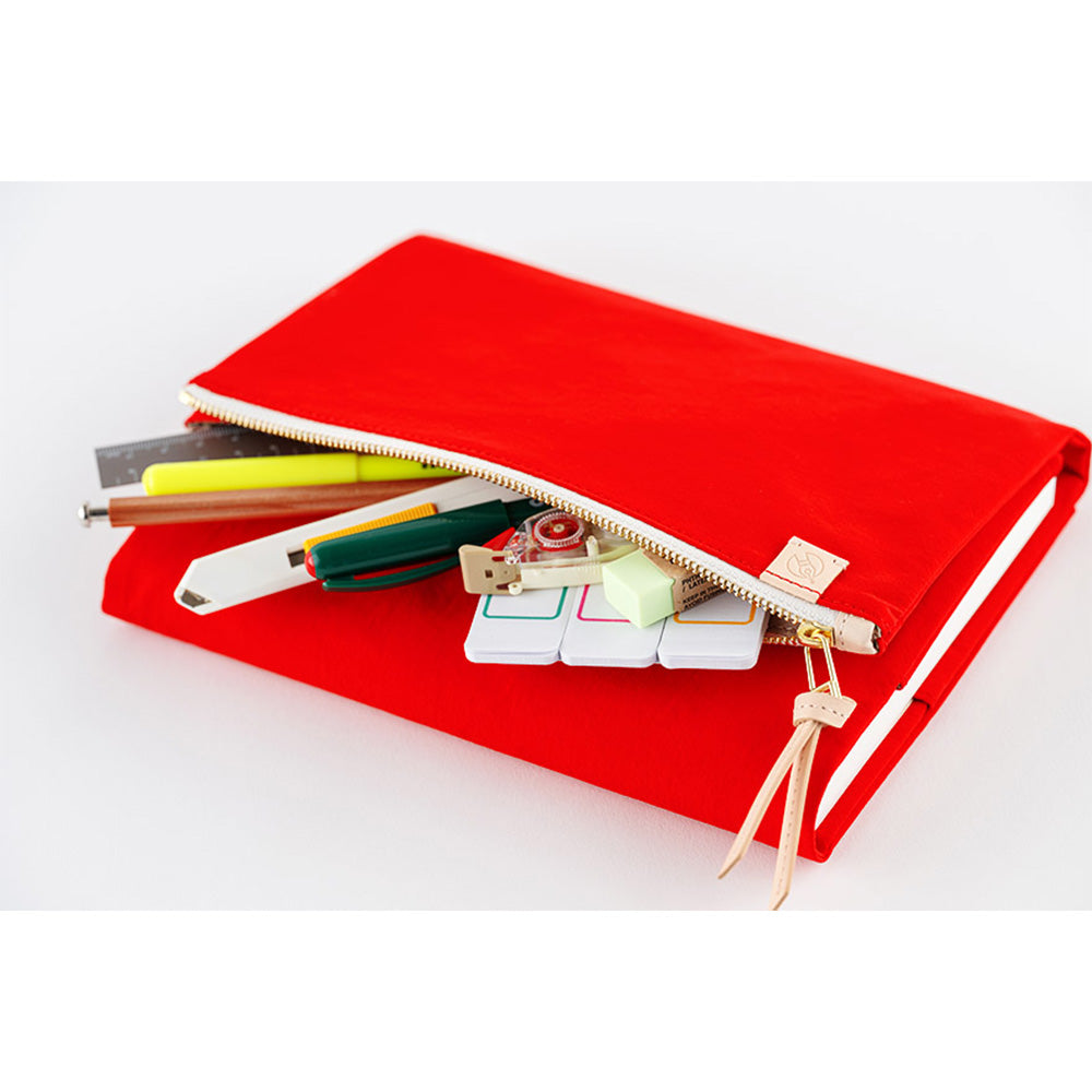 Red Hobonichi Techo A5 cover unzipped revealing stationery storage for pens and tools