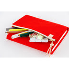 Red Hobonichi Techo A5 cover unzipped revealing stationery storage for pens and tools