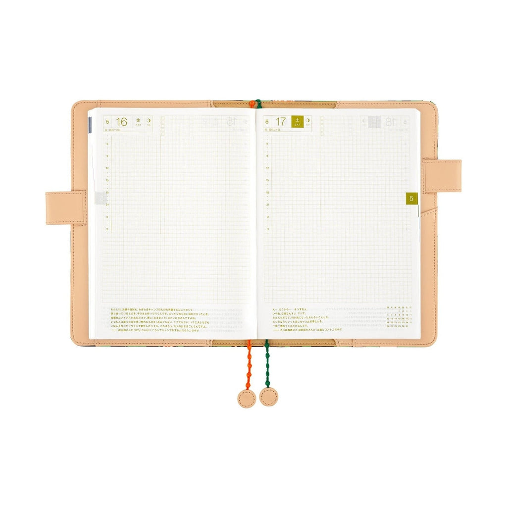 Open Hobonichi Techo A5 planner showing grid pages and date tabs with hanging tassels