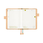Open Hobonichi Techo A5 planner showing grid pages and date tabs with hanging tassels