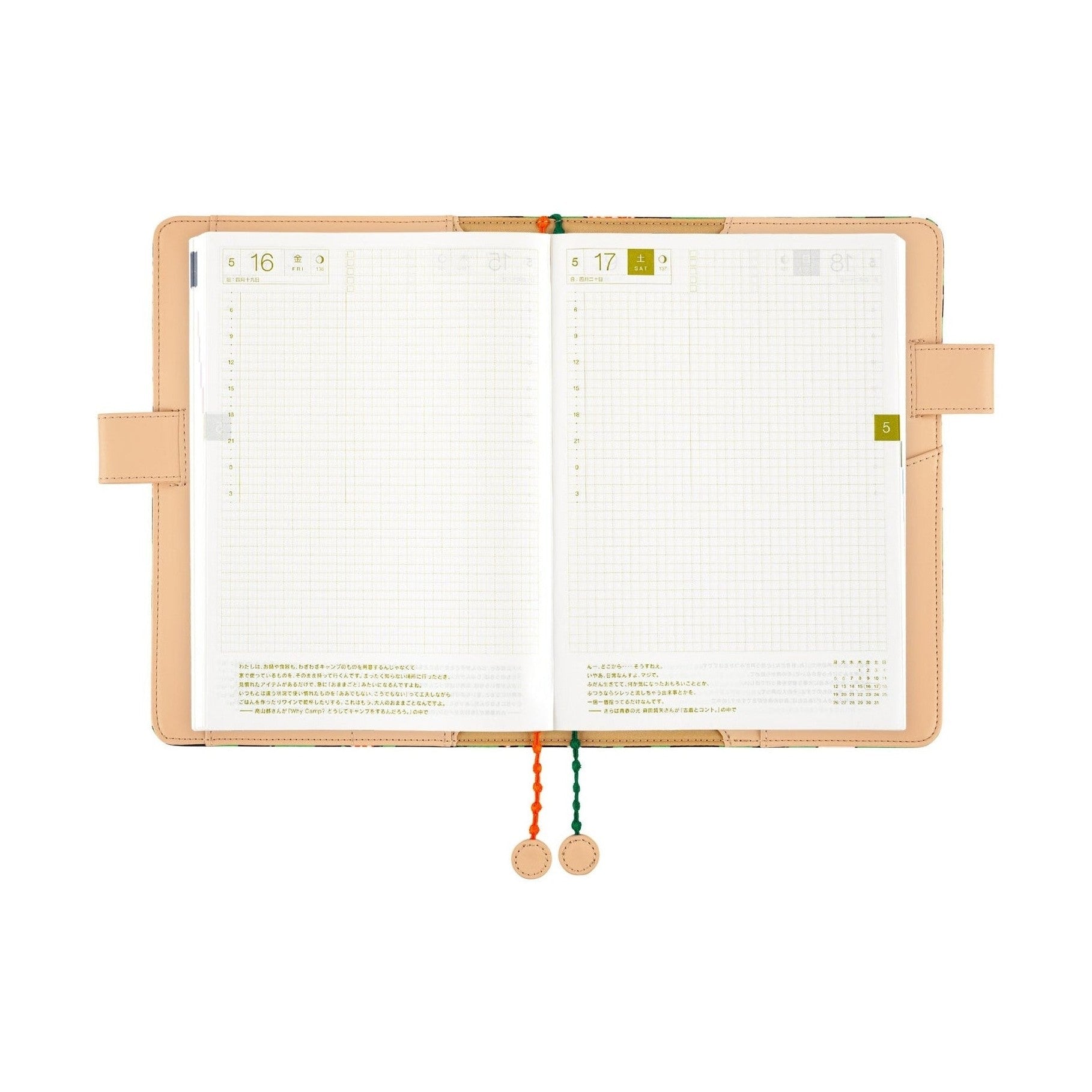Open Hobonichi Techo A5 planner showing grid pages and date tabs with hanging tassels