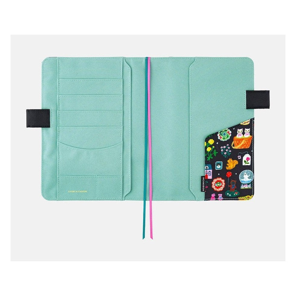Open Hobonichi Techo A5 cover showing mint green card slots and elastic straps with Yumi Kitagishi art