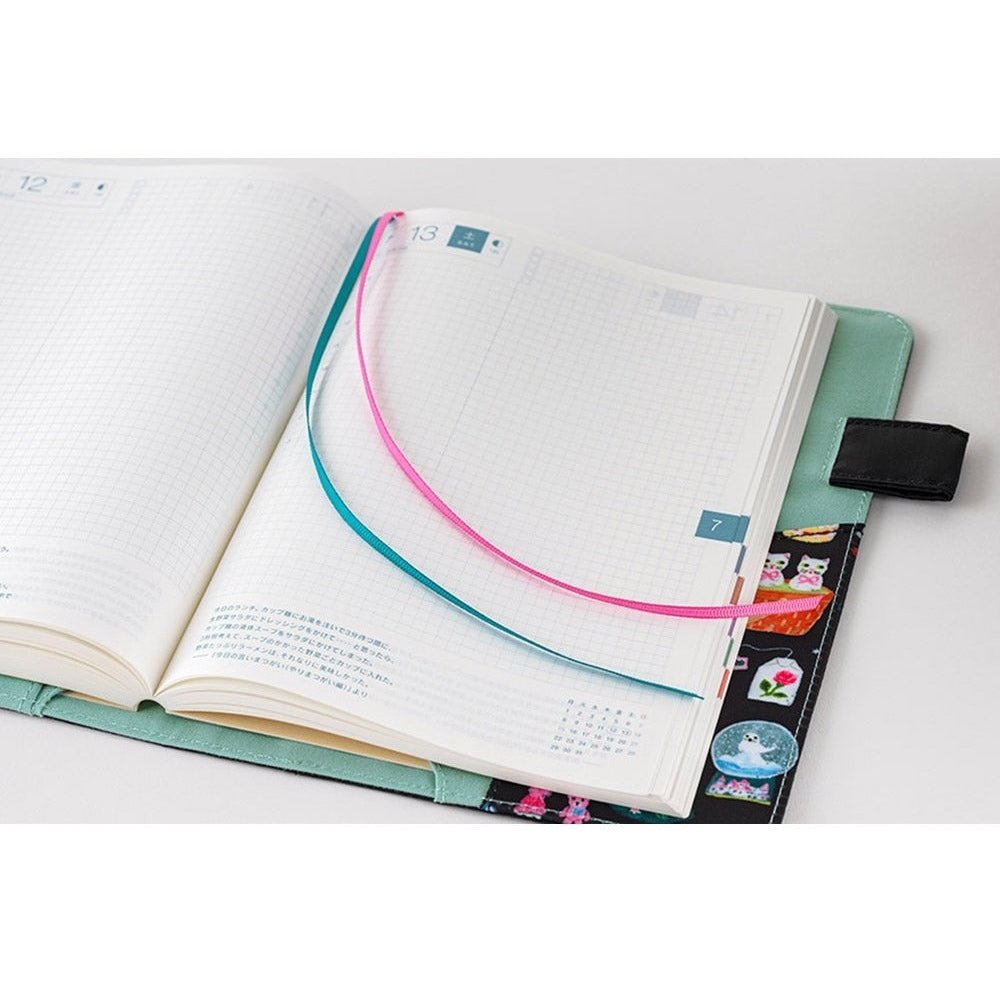 Hobonichi A5 notebook inserted into Yumi Kitagishi Little Gifts cover with grid pages and ribbon markers