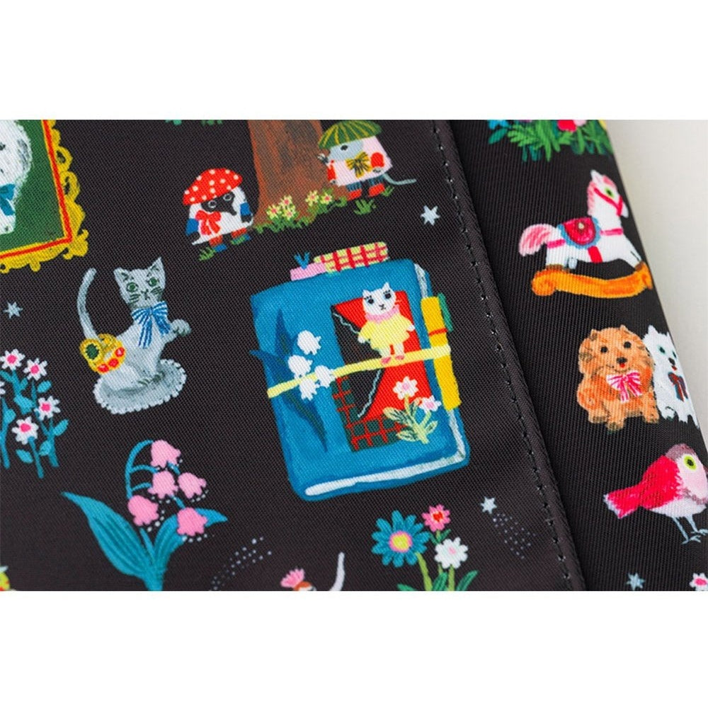 Detail shot of black woven fabric Hobonichi cover with Yumi Kitagishi cartoon animals and vibrant motifs