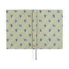 Hobonichi Techo A5 2025 Snake Toy diary open showing beige woven cover with blue snake pattern and pipe-wearing snake detail
