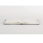 Open navy blue Hobonichi Techo diary with dotted grid pages and thick paper