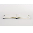 Hobonichi Techo A5 monthly layout spread with gold foil accents on off-white paper