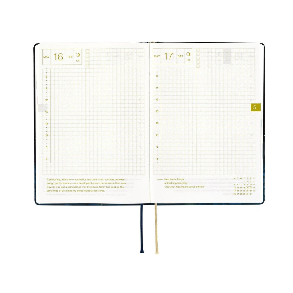 Hobonichi Techo A6 2025 diary open showing gold foil dates and grid layout with ribbon bookmark