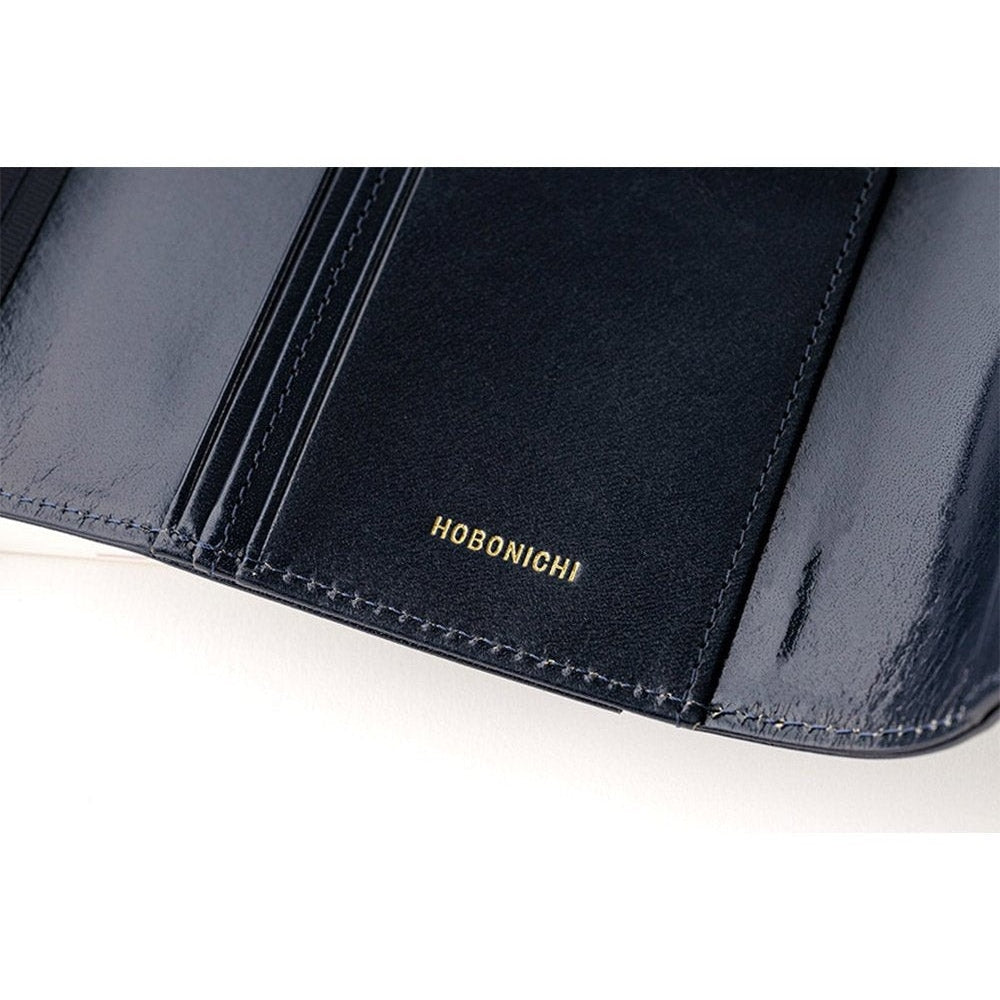 Interior left panel of navy leather cover with gold embossed Hobonichi logo and stitching