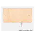 Closed beige Hobonichi Techo A6 One Piece cover featuring gold maple leaf pin and red black bookmark