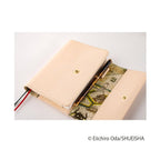 Side profile of A6 One Piece logbook showing gold snap closure and elastic band holding pen