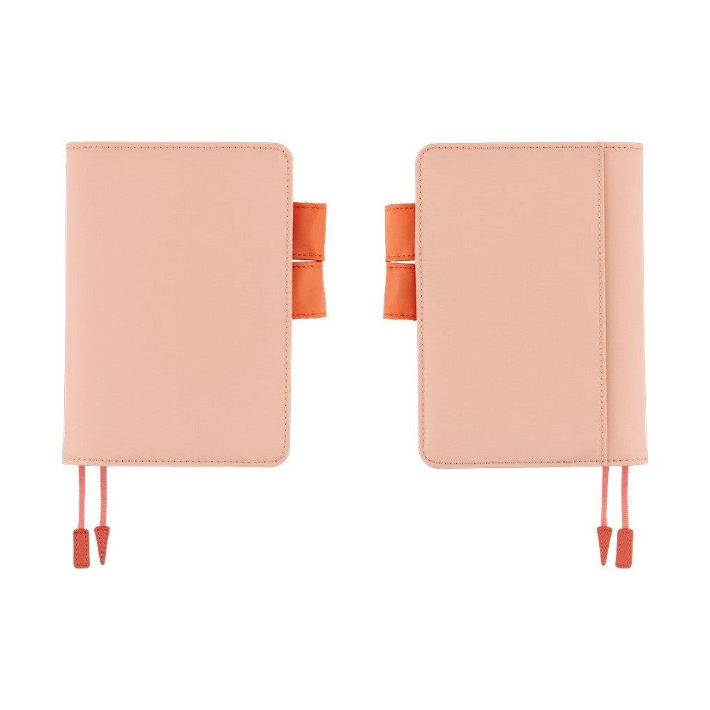 Two side-by-side light pink Hobonichi Techo A6 covers with orange accents on white background