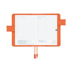 Hobonichi A6 planner open to July dates showing grid layout and orange bookmark inside
