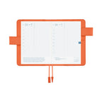 Open Hobonichi Techo A6 planner cover in airy flamingo pink with grid pages and orange clasp