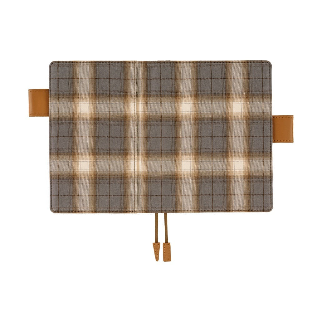Open Hobonichi A6 planner cover displaying exterior plaid pattern and central cord ties