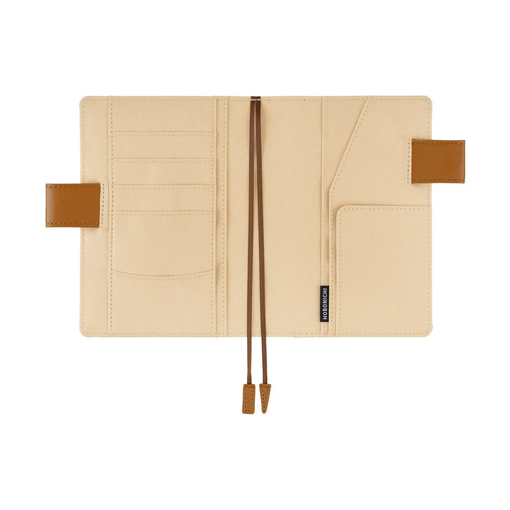 Interior of Hobonichi A6 planner cover showing beige fabric lining and multiple pockets