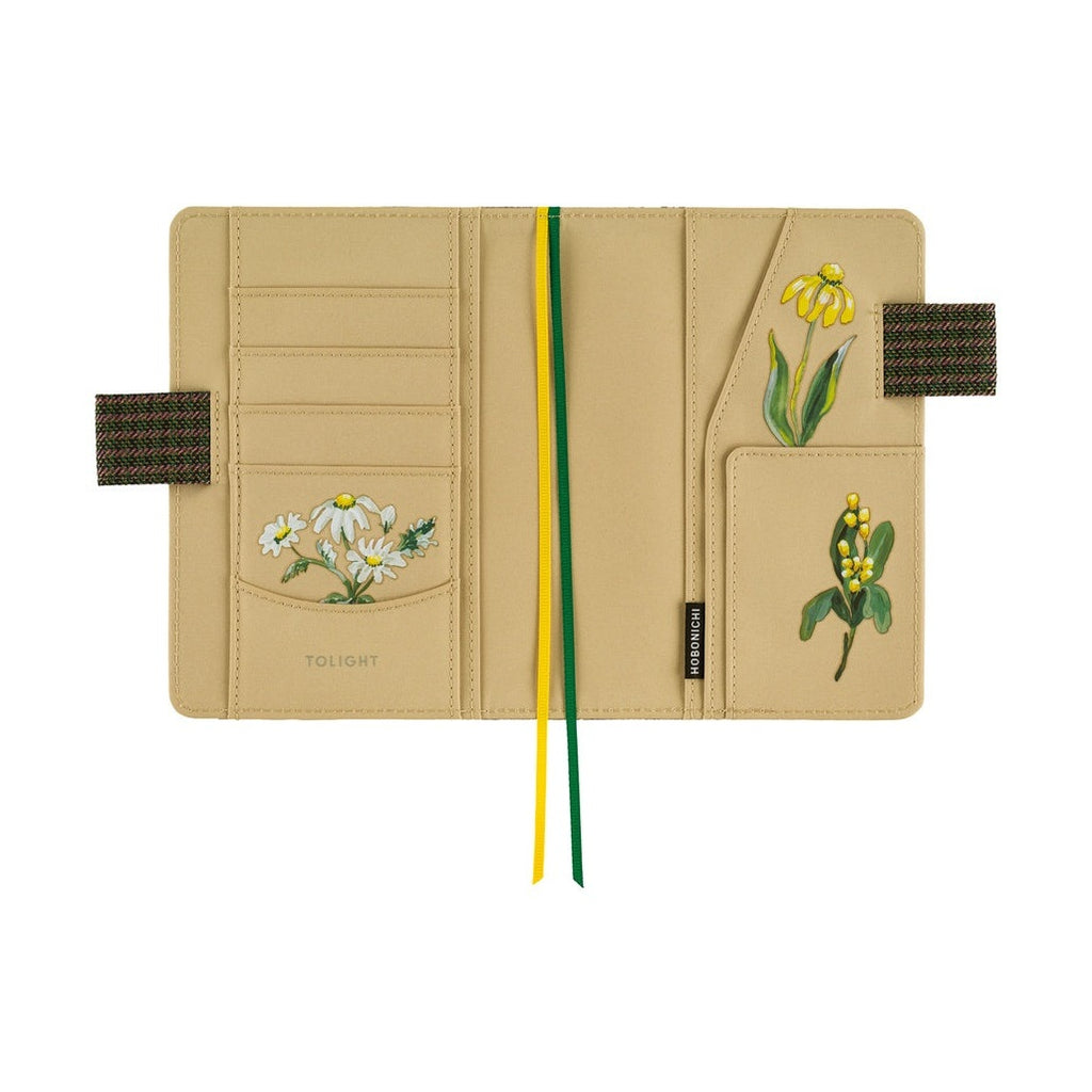 Open Hobonichi A6 planner showing beige interior pockets with TOLIGHT flower illustrations