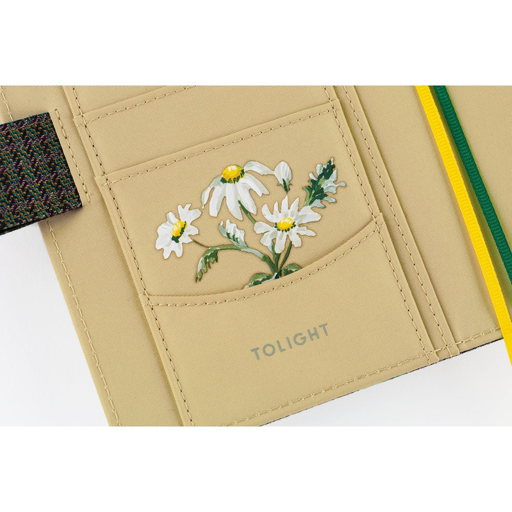 Close-up of Hobonichi planner interior pocket featuring white daisy illustration and TOLIGHT branding