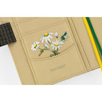 Close-up of Hobonichi planner interior pocket featuring white daisy illustration and TOLIGHT branding
