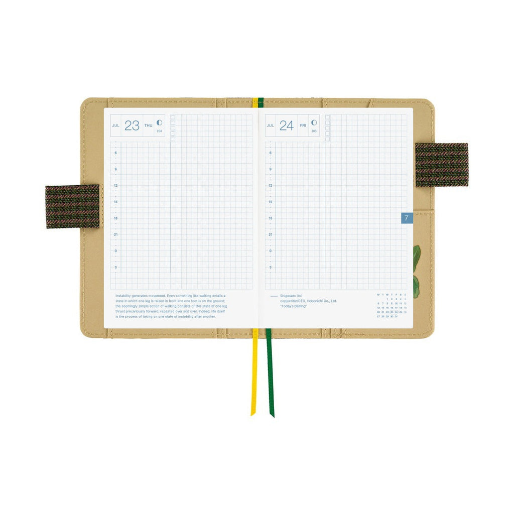 Open Hobonichi A6 planner displaying July grid daily layouts inside floral cover